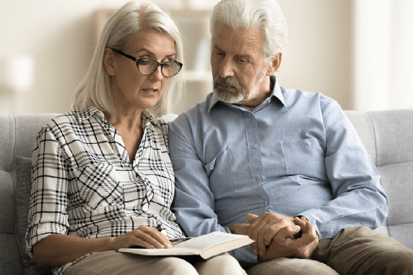 Senior adults review notebook together