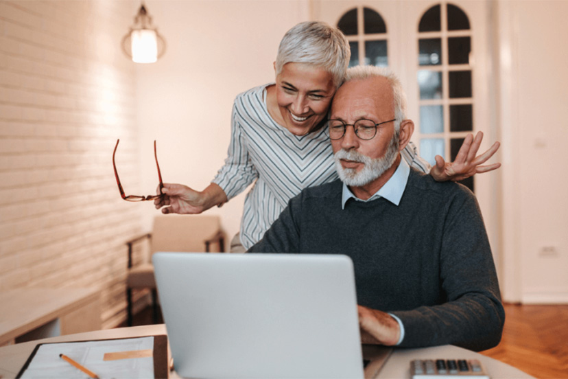 Senior couple review their budget together on laptop