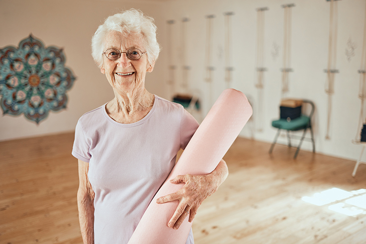 An older woman with a yoga mat