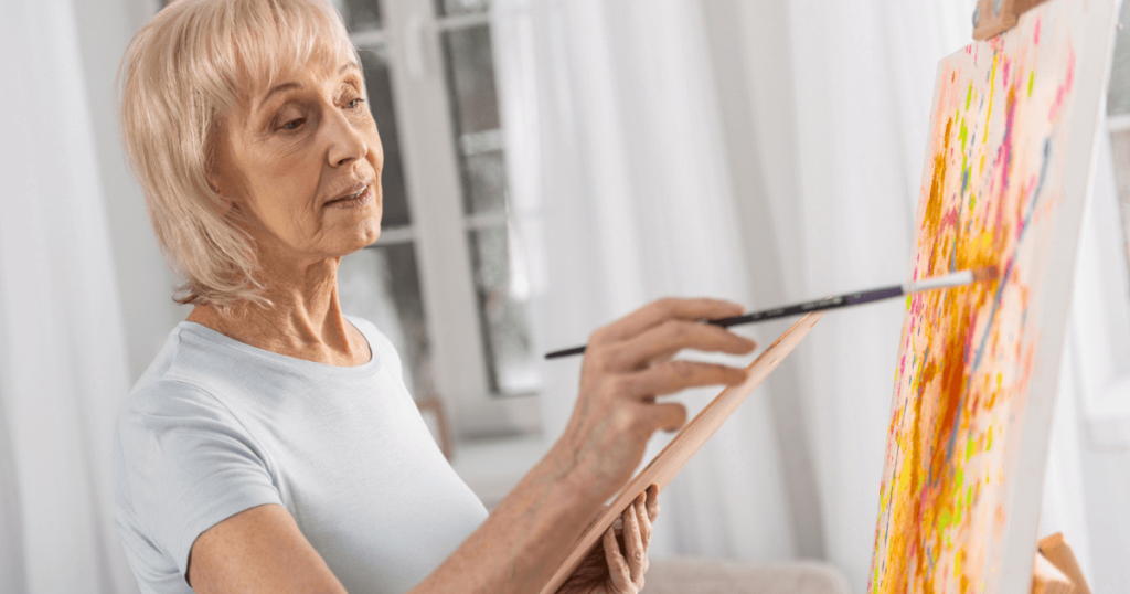 Senior woman paints canvas