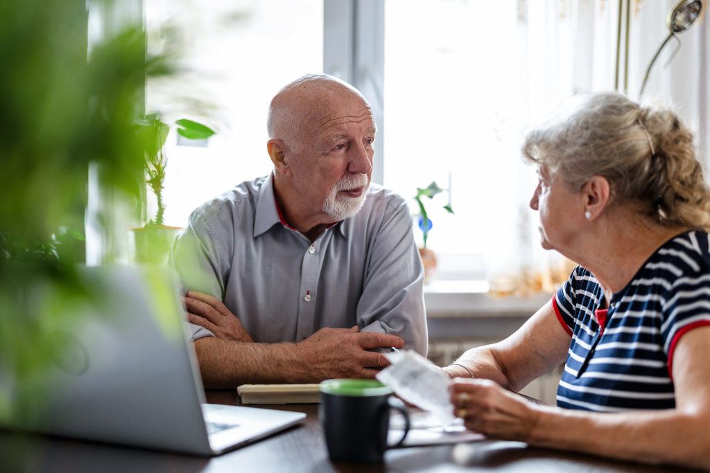 Senior couple discuss senior living over paperwork