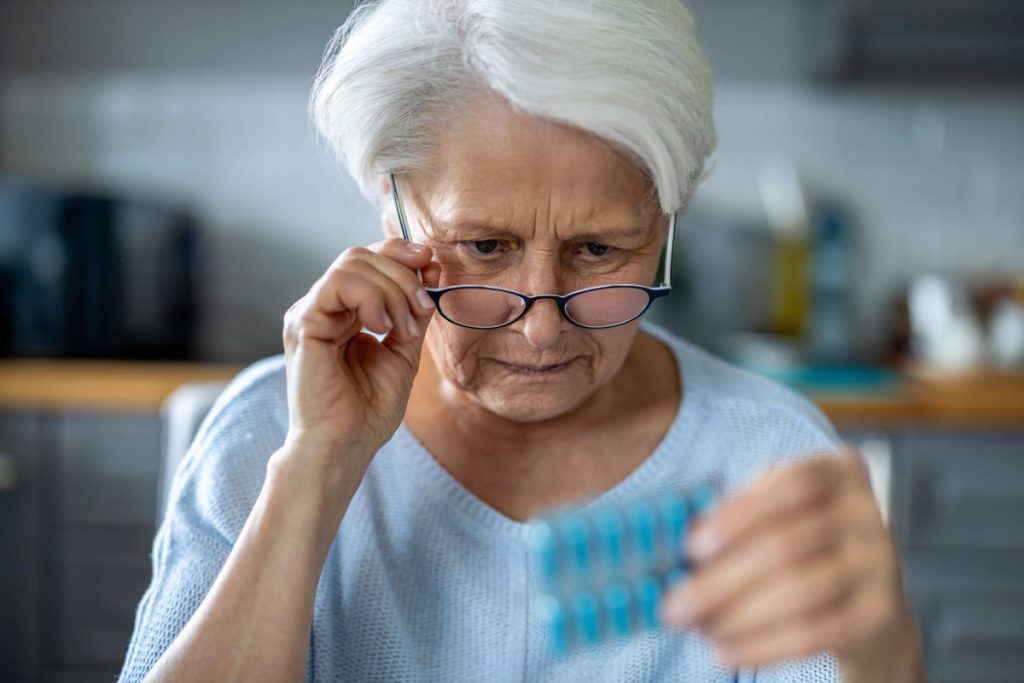 Senior woman examines medication packet