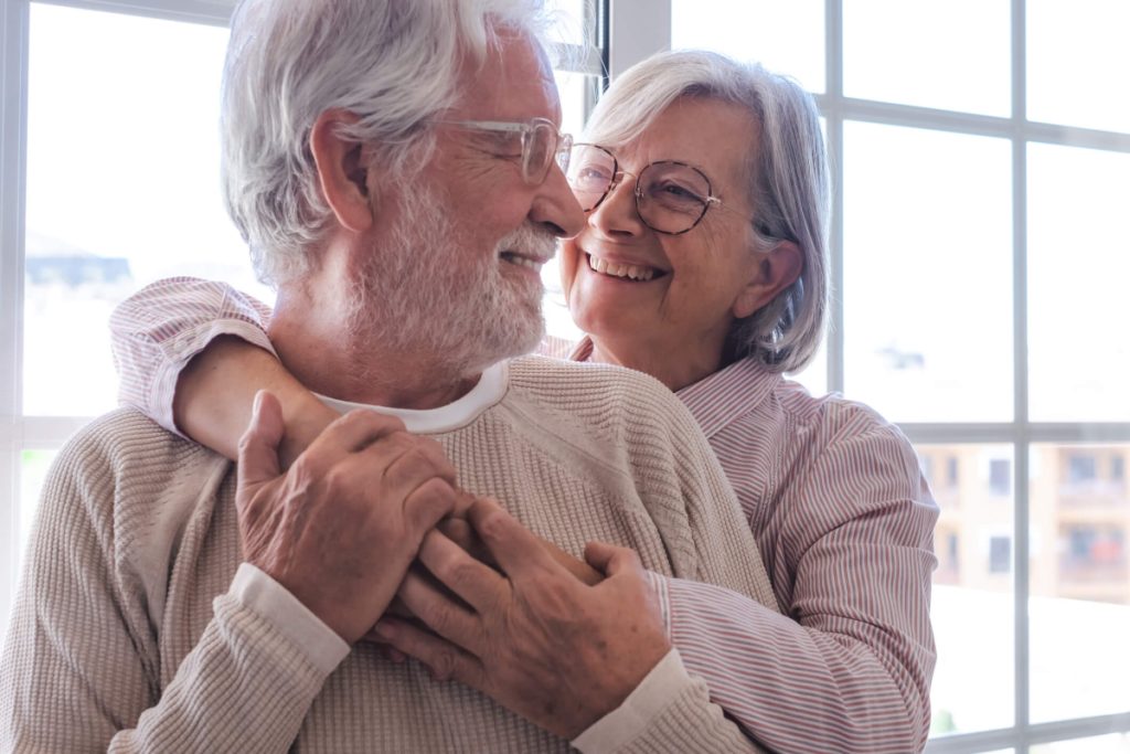 Senior couple embraces in assisted living home