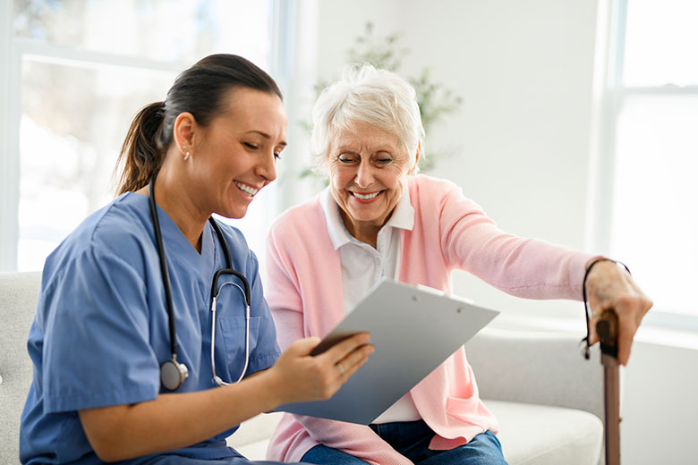 Female nurse looking over paperwork with an elderly woman