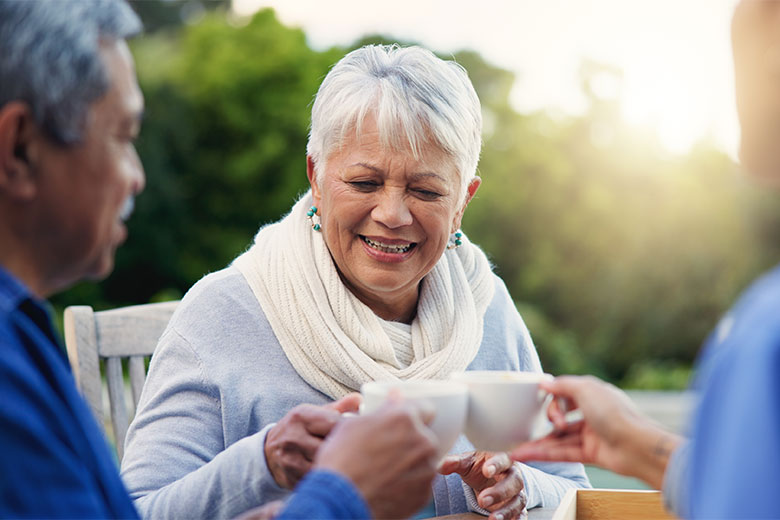 Three elderly patients having a cup of coffee