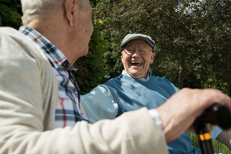 Two elderly men laughing outside