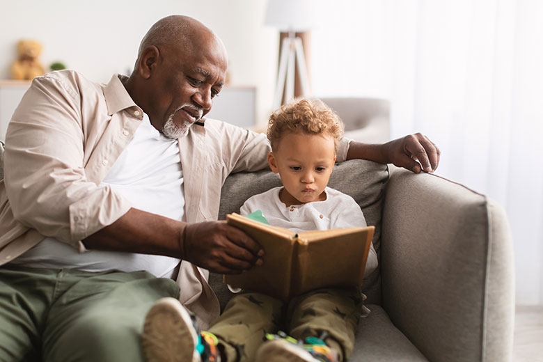 A grandfather readying a book with his grandson