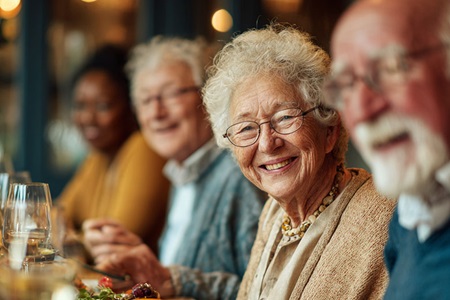 An older woman enjoys the company of friends.