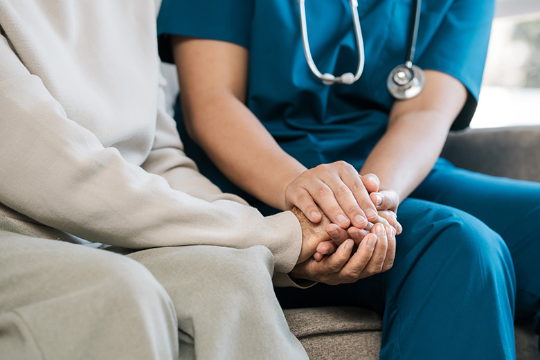 Senior and provider holding hands