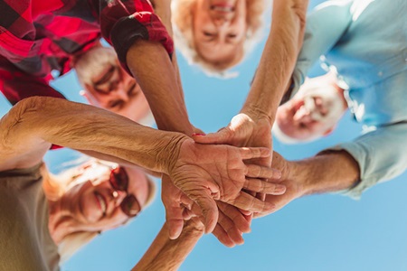 Elderly group having hands in a circle